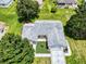 Aerial view of a well-maintained home with mature trees and a manicured lawn at 13729 Se 89Th Ave, Summerfield, FL 34491