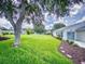 Expansive backyard featuring lush green grass and a stepping stone path leading to the home at 13729 Se 89Th Ave, Summerfield, FL 34491