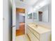 A clean bathroom featuring a vanity with a sink, a large mirror, and a door, providing a functional space at 13729 Se 89Th Ave, Summerfield, FL 34491