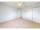 Inviting bedroom featuring carpet, ceiling fan, closet, and a doorway, providing a serene and relaxing space at 13729 Se 89Th Ave, Summerfield, FL 34491