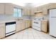 A bright kitchen featuring white appliances, ample counter space, and tile flooring at 13729 Se 89Th Ave, Summerfield, FL 34491