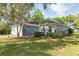 Charming single-story home featuring a detached garage, manicured lawn, and mature trees at 1606 Center St, Deland, FL 32720