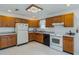 Functional kitchen features oak cabinets, white appliances, and laminate countertops at 1606 Center St, Deland, FL 32720