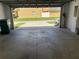 View of the garage with concrete floors and an exterior view of the lawn and neighboring homes at 387 Winter Nellis Cir, Winter Garden, FL 34787
