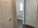 Hallway features two doors and a glimpse of a bathroom with a window at 387 Winter Nellis Cir, Winter Garden, FL 34787