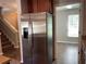 Modern stainless steel refrigerator and view into the living room at 387 Winter Nellis Cir, Winter Garden, FL 34787
