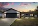 Charming single-story home with a two-car garage and manicured front lawn against a vibrant sunset backdrop at 15690 Sw 46Th Cir, Ocala, FL 34473