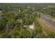 A captivating aerial perspective reveals a quaint home embraced by verdant trees alongside a highway at 3333 Se 3Rd Ave, Ocala, FL 34471
