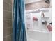 Shower with gray tiling, white shelving, and a blue shower curtain at 3333 Se 3Rd Ave, Ocala, FL 34471