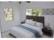 Well-lit bedroom featuring a plush bed with a blue runner and end tables at 124 Auburn Rd, Auburndale, FL 33823