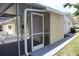 The exterior of this home features a screened-in porch, sliding glass door, and a neutral color scheme at 124 Auburn Rd, Auburndale, FL 33823