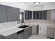 Kitchen with gray cabinets, stainless appliances, and white countertops at 124 Auburn Rd, Auburndale, FL 33823