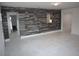 Spacious living room with hardwood accent wall and bright white floors and walls at 124 Auburn Rd, Auburndale, FL 33823