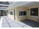 This covered patio area features neutral colors, a screen enclosure, and a door to the exterior of the house at 124 Auburn Rd, Auburndale, FL 33823