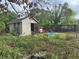 Exterior view of backyard shed in overgrown area at 1400 Hayward Ave, Deltona, FL 32738
