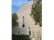 Side view of home with high windows, lush foliage, and exterior utilities at 9826 Poplar Pl, Orlando, FL 32827
