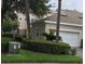 Side view of stucco home showing attached garage, privacy wall, and lovely landscaping at 9826 Poplar Pl, Orlando, FL 32827
