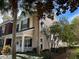 Inviting two-story townhouse with neutral stucco, black shutters, and lush landscaping at 9826 Poplar Pl, Orlando, FL 32827