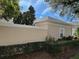 Neutral stucco home exterior with tasteful landscaping and partial privacy wall at 9826 Poplar Pl, Orlando, FL 32827