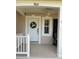 Inviting front door with decorative wreath and covered porch area with fan at 9826 Poplar Pl, Orlando, FL 32827