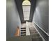 Stairwell with carpeted steps and a railing under an arched window at 9826 Poplar Pl, Orlando, FL 32827