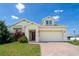 Charming home with a two-car garage and a brick paved driveway, complimented by a green lawn and mature landscaping at 1720 Reflection Ln, St Cloud, FL 34771