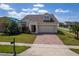 Charming home with a two-car garage and a brick paved driveway, complimented by a green lawn and mature landscaping at 1720 Reflection Ln, St Cloud, FL 34771