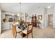 Bright dining area featuring modern light fixture, glass table, and chairs open to kitchen at 1139 Santa Cruz Dr, The Villages, FL 32162