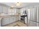 Bright kitchen with stainless steel appliances, white cabinets, granite countertops, and tile flooring at 1139 Santa Cruz Dr, The Villages, FL 32162