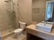 This bathroom features a glass-doored shower, modern toilet, and contemporary sink with elegant finishes at 3060 Rockefeller Way # 156, Kissimmee, FL 34747