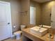 Bathroom featuring a rectangular sink with chrome fixtures, toilet, and vanity with tiled wall at 3060 Rockefeller Way # 156, Kissimmee, FL 34747