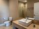 Bathroom featuring a modern square sink, marble countertop and a glass-enclosed shower with tiled walls at 3060 Rockefeller Way # 156, Kissimmee, FL 34747