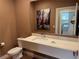 Bathroom showcasing a floating vanity with modern fixtures, toilet, and a large mirror reflecting the laundry room at 3060 Rockefeller Way # 156, Kissimmee, FL 34747
