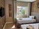 This bedroom features two twin beds, wood accent wall and decor, as well as a window with exterior views at 3060 Rockefeller Way # 156, Kissimmee, FL 34747