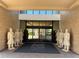 Building entrance adorned with terracotta soldier statues and a Magic Village Views mat at 3060 Rockefeller Way # 156, Kissimmee, FL 34747