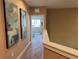 Hallway with neutral colors, with artwork on the walls leads to a bedroom, providing a welcoming space at 3060 Rockefeller Way # 156, Kissimmee, FL 34747
