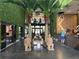 A stunning lobby with lush greenery, towering palm trees, and eye-catching statues creates a grand entrance at 3060 Rockefeller Way # 156, Kissimmee, FL 34747