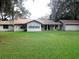 Rear exterior view of a single-story ranch home with a well-manicured lawn at 3 Lakeside Dr, Ocala, FL 34482