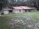 Exterior side view of ranch home and attached building with covered walkway at 3 Lakeside Dr, Ocala, FL 34482