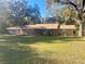 Ranch-style home featuring a welcoming front porch with chairs and mature trees at 3 Lakeside Dr, Ocala, FL 34482