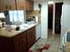 Traditional kitchen features wood cabinets, a white refrigerator, and a kitchen sink at 3 Lakeside Dr, Ocala, FL 34482