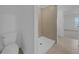 Bathroom with a white toilet and a walk-in shower tiled in neutral tones at 744 Osprey Roost Dr, Lakeland, FL 33801