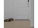 A clean, tiled entryway featuring a white door and shoes in the foreground at 744 Osprey Roost Dr, Lakeland, FL 33801