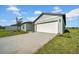 Attractive home featuring a two-car garage, manicured lawn, and a paved driveway at 744 Osprey Roost Dr, Lakeland, FL 33801
