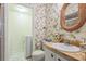Bathroom with floral wallpaper, vanity, mirror, and step-in shower at 159 Sweetgum Ln, Port Orange, FL 32129