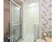 Vintage bathroom featuring a glass shower, floral wallpaper and laundry room area at 159 Sweetgum Ln, Port Orange, FL 32129