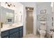 Well-lit bathroom features a shower, framed mirror, blue vanity, and ample counter space at 11540 Sw 84Th Avenue Rd, Ocala, FL 34481