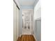 Hallway view of clean and organized bathroom with toilet, shower, and wooden laminate flooring at 11540 Sw 84Th Avenue Rd, Ocala, FL 34481