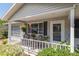 Inviting front porch with wicker seating and plants creates a cozy outdoor space at 11540 Sw 84Th Avenue Rd, Ocala, FL 34481