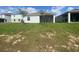 Back exterior view of a home with a well-maintained lawn and a screened-in porch at 4910 Lyric Dr, Mascotte, FL 34753